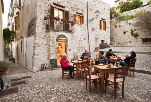 a group of people sitting at tables in an alley at Residenza d'Epoca Borgodifiume in Fiumefreddo Bruzio