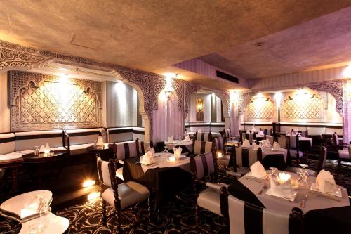 a restaurant with tables and chairs in a room at Broadway Hotel in Dubai