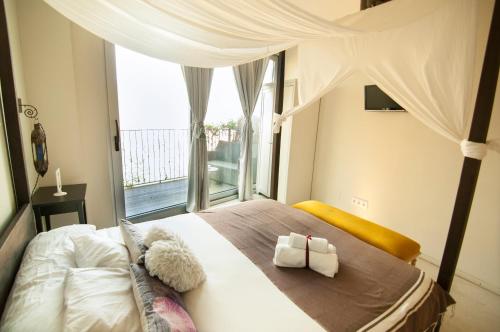 a bedroom with a large bed with a large window at Les Suites in Santa María de Palautordera