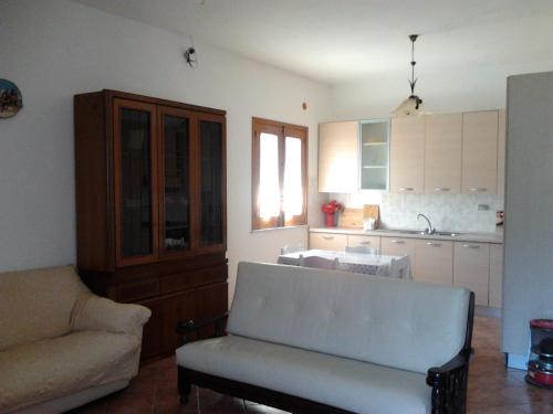a living room with a couch and a kitchen at Casa Vacanze Campagna&mare in Pollina