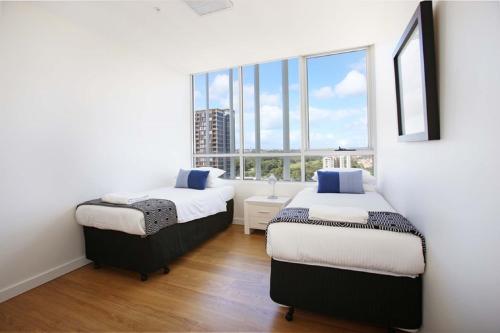 Moore to See - Modern and Spacious 3BR Zetland Apartment with Views over Moore Park tesisinde bir odada yatak veya yataklar