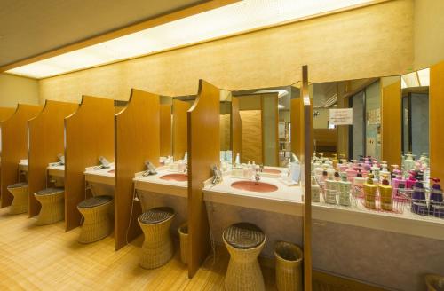 a public bathroom with three sinks and a row of mirrors at Kohan-no-Yado Morimoto in Kaga