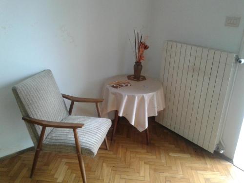 a table with a chair and a table with a vase on it at Guest House Rože in Ilirska Bistrica