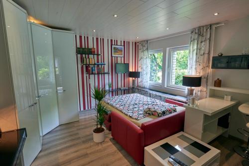 sala de estar con sofá rojo y mesa en Ittertal Apartment, en Solingen