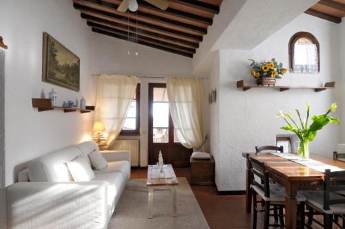a living room with a white couch and a table at Appartamento San Simone in Castiglione della Pescaia