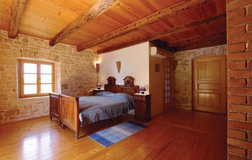 a bedroom with a bed and a brick wall at Villa Dusan 1212 in Svetvinčenat