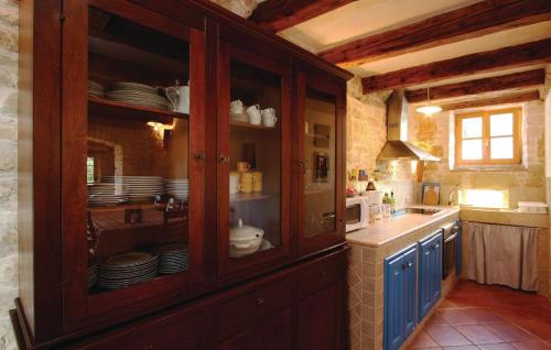 a kitchen with a large wooden cabinet with dishes in it at Villa Dusan 1212 in Svetvinčenat