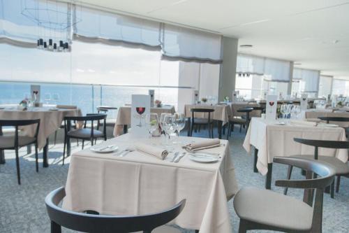 a dining room with tables and chairs with white table cloth at Palace Bonanza Playa Resort & SPA by Olivia Hotels Collection in Illetas