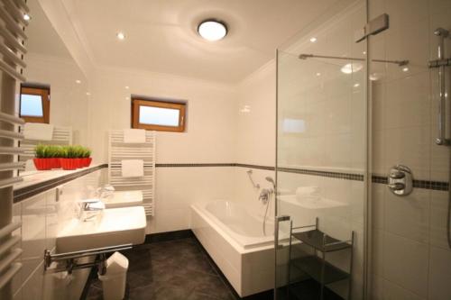 La salle de bains est pourvue d'une baignoire, d'un lavabo et d'une douche. dans l'établissement Almliesl ZELL-365, à Zell am See