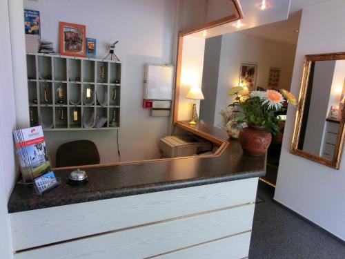 La salle de bains est pourvue d'un miroir et d'un lavabo. dans l'établissement Hotel Hinz, à Bad Oldesloe