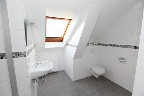 a white bathroom with a sink and a toilet at Appartementhotel in Stade in Stade