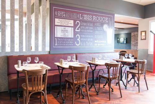 a dining room with tables and chairs and a chalkboard at ibis Falaise Coeur de Normandie in Falaise