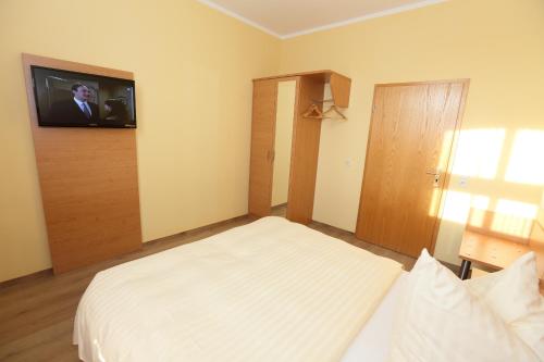 Schlafzimmer mit einem Bett und einem TV an der Wand in der Unterkunft Appartementhotel in Stade in Stade