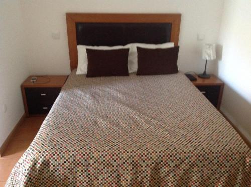 a bedroom with a large bed with a wooden headboard at Curral de l Tiu Pino in Sendim