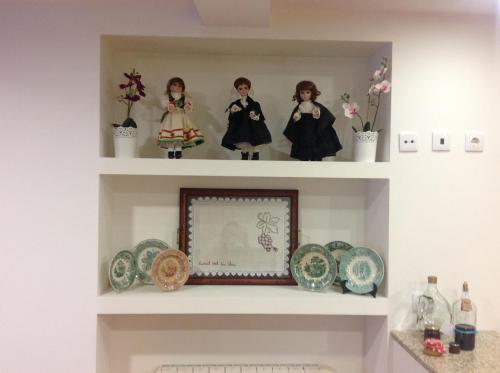 two shelves with dolls and plates on them at Curral de l Tiu Pino in Sendim