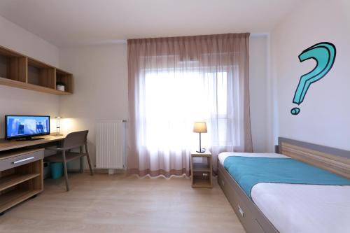 - une chambre avec un lit, un bureau et une fenêtre dans l'établissement Apparteo Bordeaux, à Bordeaux