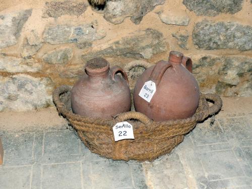 two vases sitting in a basket on a stone wall at Curral de l Tiu Pino in Sendim