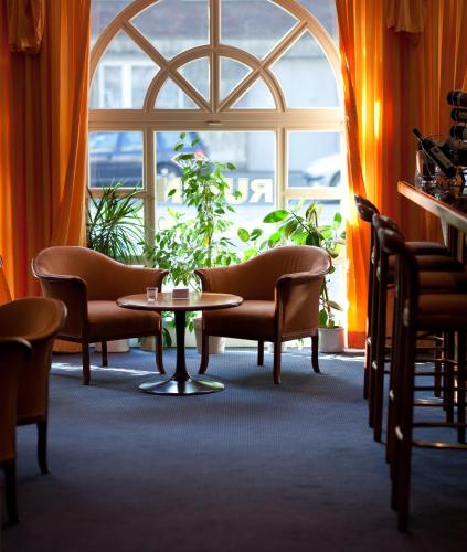 a room with chairs and a table and a window at Hotel Rubin in Düsseldorf