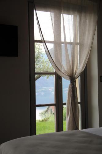 a bedroom with a window with a view of a field at Agriturismo Treterre in Pianello Del Lario