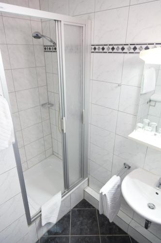 a bathroom with a shower and a sink at Hotel Rubin in Düsseldorf