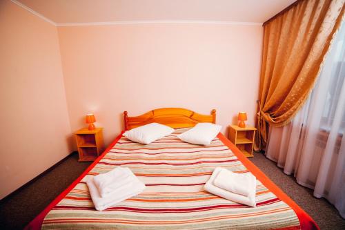 a bedroom with a large bed with two pillows at Pansionat Slavskiy in Slavske
