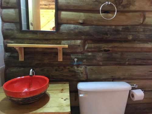 een badkamer met een rode wastafel en een toilet bij Enkel Cabañas in José de la Quintana