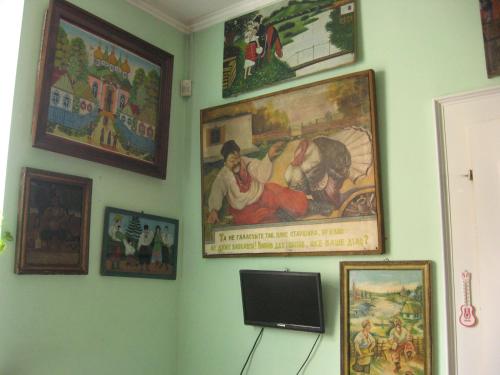 a wall with pictures and a tv in a room at Vilni Kimnaty in Mukacheve