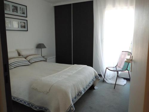 1 dormitorio con 1 cama, 1 silla y 1 ventana en LE CESAREE 3J, en Fréjus