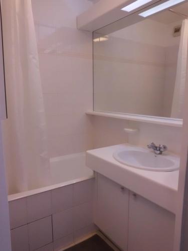 une salle de bain blanche avec un lavabo et un miroir dans l'établissement LE CESAREE 3J, à Fréjus