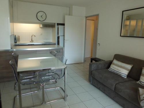 un salon avec un canapé et une cuisine dans l'établissement LE CESAREE 3J, à Fréjus