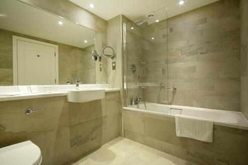 a bathroom with a sink and a tub and a toilet at Trout Hotel in Cockermouth