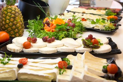 a table filled with different types of cheese and vegetables at Hotel Luxor in Playa de Palma