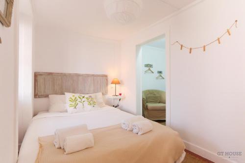 リスボンにあるSanto António Apartmentの白いベッドルーム(タオル付きのベッド付)