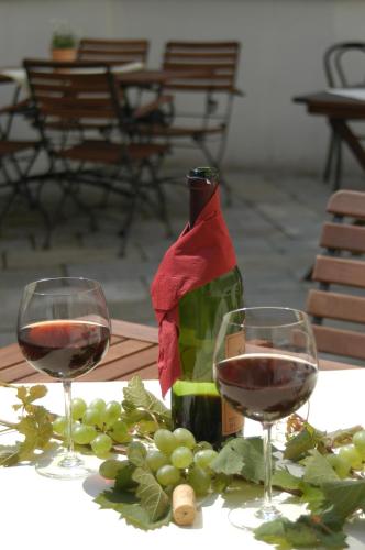 two glasses of wine sitting on a table with grapes at Sax Imperial in Dresden