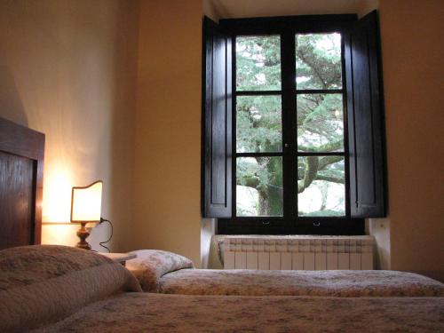 a bedroom with two beds and a window at Locanda Dei Baroni - Antica Dimora in Camaldoli