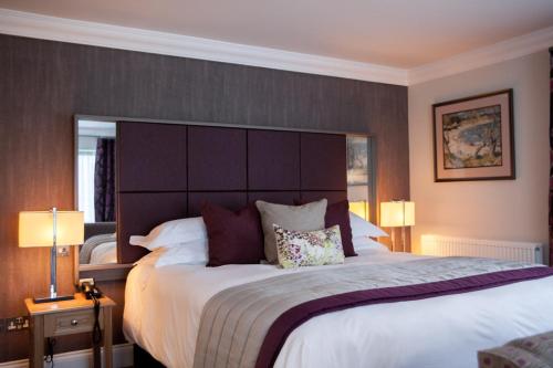 a bedroom with a large bed with a large headboard at Trout Hotel in Cockermouth