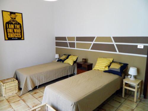 sypialnia z 2 łóżkami i znakiem na ścianie w obiekcie Casa Relax Mare Trebisacce w mieście Trebisacce
