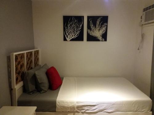 a bedroom with a bed with three pictures on the wall at The VRNON Boutique by MY hostel in Boracay