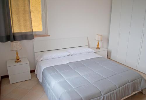 a white bed in a bedroom with two lamps at Villa Benvenuto in Costermano sul Garda
