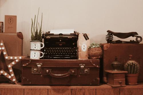 a shelf with two suitcases and an old typewriter at Mr. Jordaan in Amsterdam