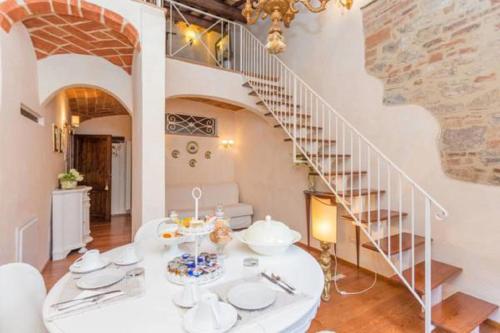 a dining room with a white table and a staircase at B&B Antica Gabella in Castiglione del Lago