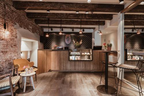 a restaurant with brick walls and a counter with chairs at Mr. Jordaan in Amsterdam