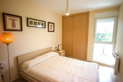1 dormitorio con cama y ventana en Apartamento Premium Playa Altar 2, en Barreiros