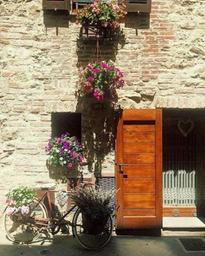 a bicycle parked in front of a building with flowers at B&B Antica Gabella in Castiglione del Lago