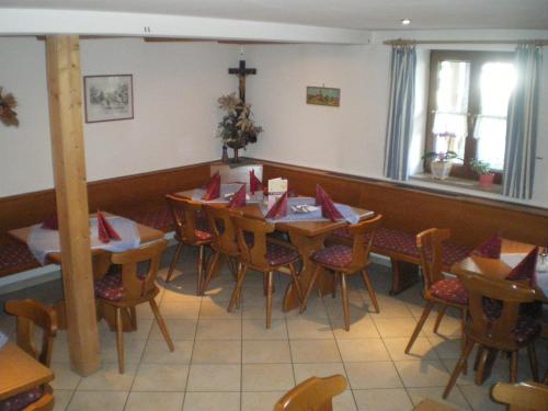 a dining room with tables and chairs and a cross on the wall at Gasthaus und Landhotel Wiedmann in Eresing