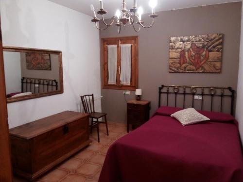 1 dormitorio con cama, mesa y espejo en Casa Rural Benede en Chibluco