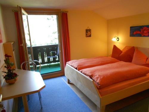 a bedroom with a bed with orange sheets and a window at Haus Thurner in Obsteig