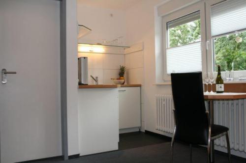 ケルンにあるApartment-Hausのキッチン(カウンター、テーブル、椅子付)