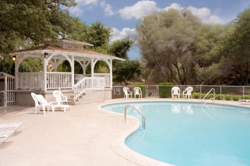 a swimming pool with chairs and a gazebo at Lazy J Ranch Motel in Three Rivers