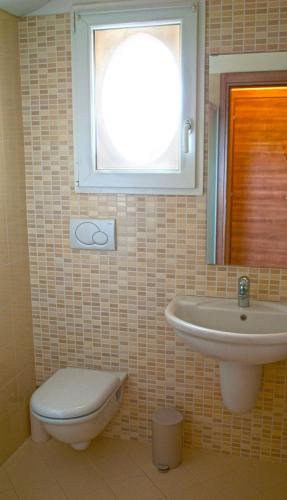 a bathroom with a sink and a toilet and a window at Villa Benvenuto in Costermano sul Garda